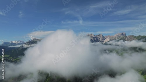 Aerial footage of a drone flying through clouds slowly turning right unveiling the peak Sass de Putia. Embark on an enchanting aerial journey through the Dolomites. LuPa Creative
