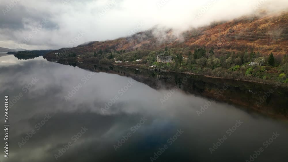 Forward Drone View of Majestic Lake Surrounded by Towering Mountains on an Overcast Day Forward Drone View of Majestic Lake Surrounded by Towering Mountains on an Overcast Day