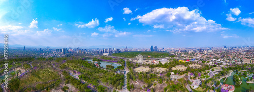 An aerial panorama of Chapultepec Forest in Mexico City, showing the immensity of this green area in contrast with a deep blue sky. The cityscape in the background enhances the scenic beauty. photo