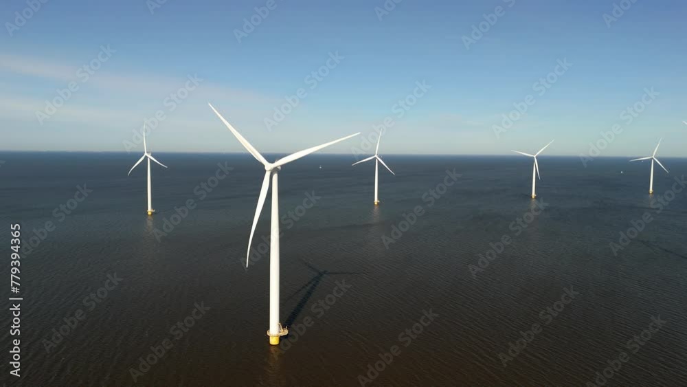 Windmill park in the ocean, drone aerial view of windmill turbines generating green energy electrically, windmills isolated at sea in the Netherlands. Lake Ijsselmeer