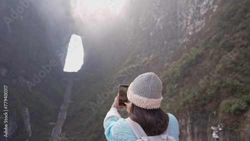 Young female tourist taking a photo of the The Heaven's Gate at Tianmen Shan national park, The famous tourist destination at Zhangjiajie photo