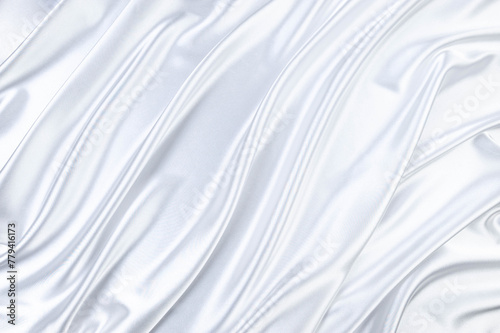 Luxury white satin background. Soft and elegant silk fabric. Flowing waves textile. Top view.