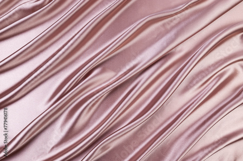 Luxury pink beige satin background. Soft and elegant silk fabric. Flowing waves textile. Top view.