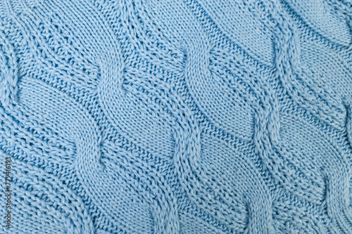 Blue knitted fabric background. Knitted braids texture. 
