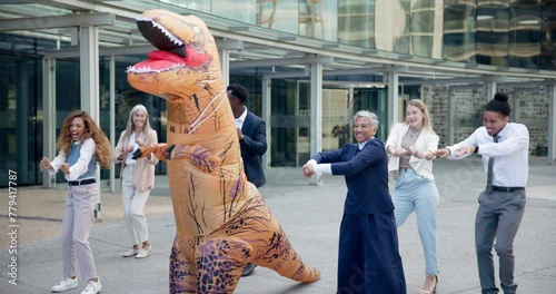 Business, people and dance outdoor in costume of inflatable dinosaur with fun and happiness at office. Funny, group and crazy team building at workplace with excited energy or comedy character photo