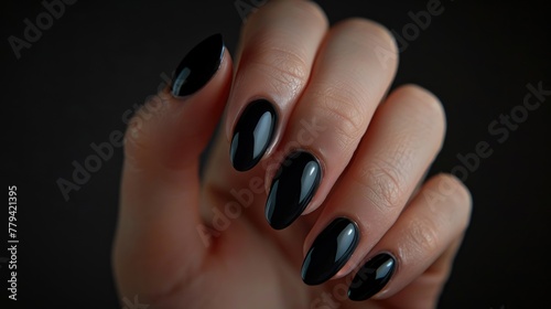 Close-up of black glossy stiletto nails.