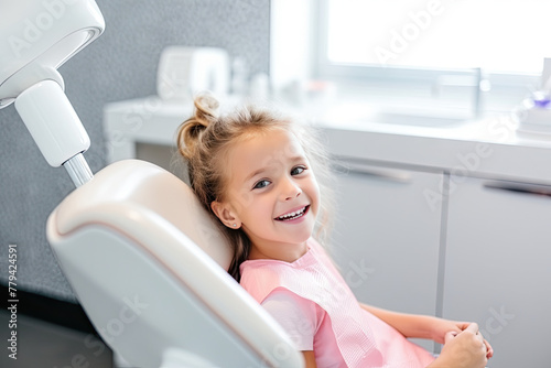Happy Little Girl Smiling in a Dental Chair During a Checkup with a Pediatric Dentist
