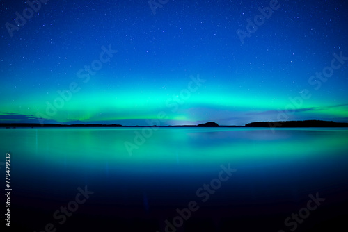 Northern lights dancing over calm lake in north of Sweden © Conny Sjostrom