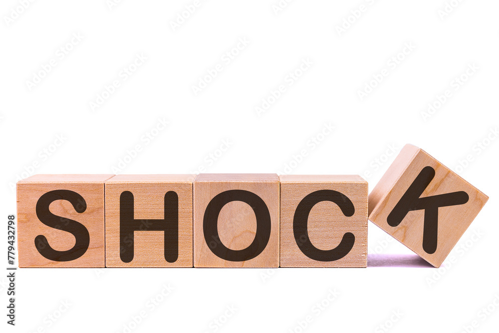 Word SHOCK is made of wooden building blocks lying on the table and on a light background. Concept. Word SHOCK is made of wooden building blocks lying on the table and on a light background. Concept.