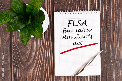 Fair Labor Standarts Act FLSA - handwriting on a notebook with pen photo