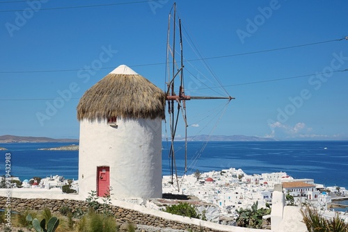 Traditional Greek windmill synonymous with Mykonoian architecture overlooking the Old Town and Aegean Sea in Mykonos, Greece