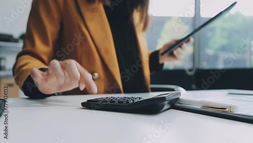 Young confident successful businesswoman using laptop and digital tablet, focused on work, creating business strategy plans on tablet. Female business professional distantly working online from home. photo