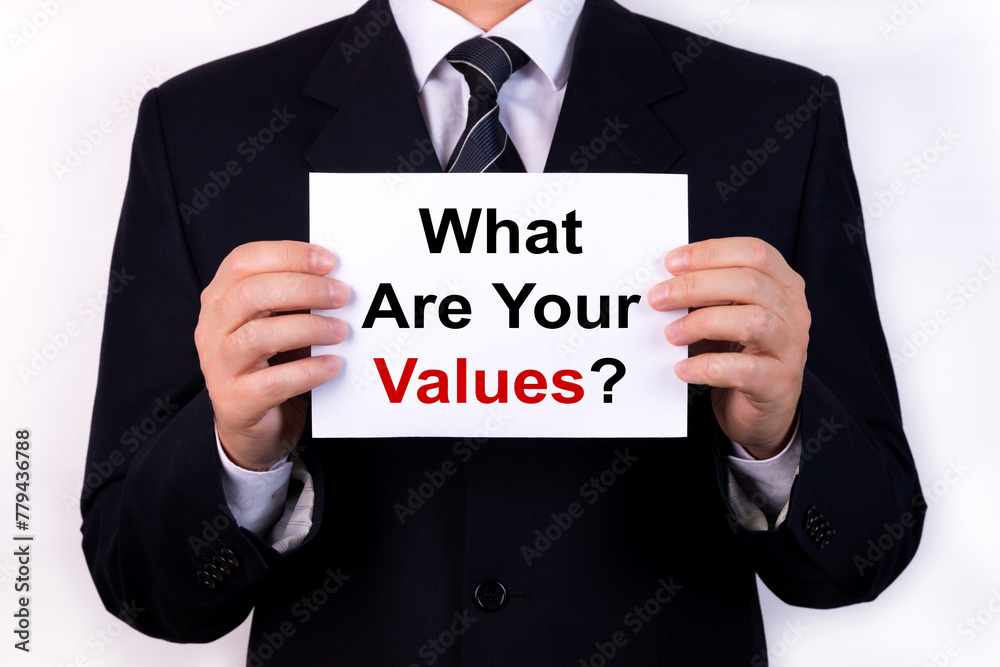 Businessman holds a tablet with the text WHAT ARE YOUR VALUES. Business concept Businessman holds a tablet with the text WHAT ARE YOUR VALUES. Business concept