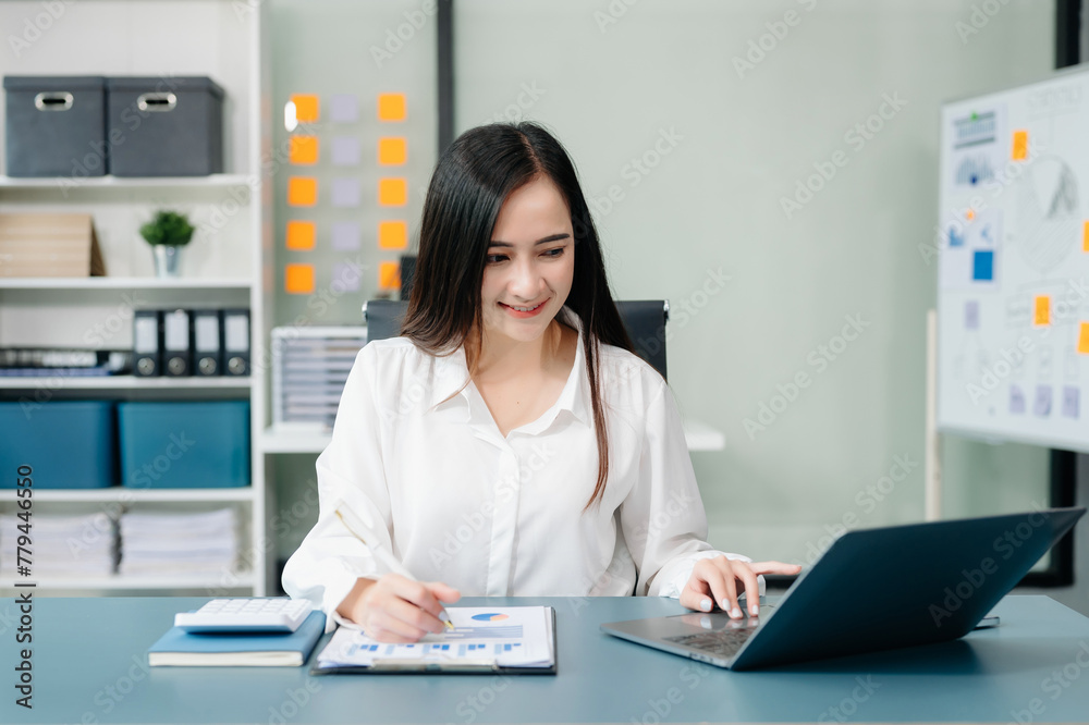 Asian businesswoman working with working notepad, tablet and laptop documents talking on the smartphone, tablet and laptop video call tax Asian businesswoman working with working notepad, tablet and laptop documents talking on the smartphone, tablet and laptop video call tax