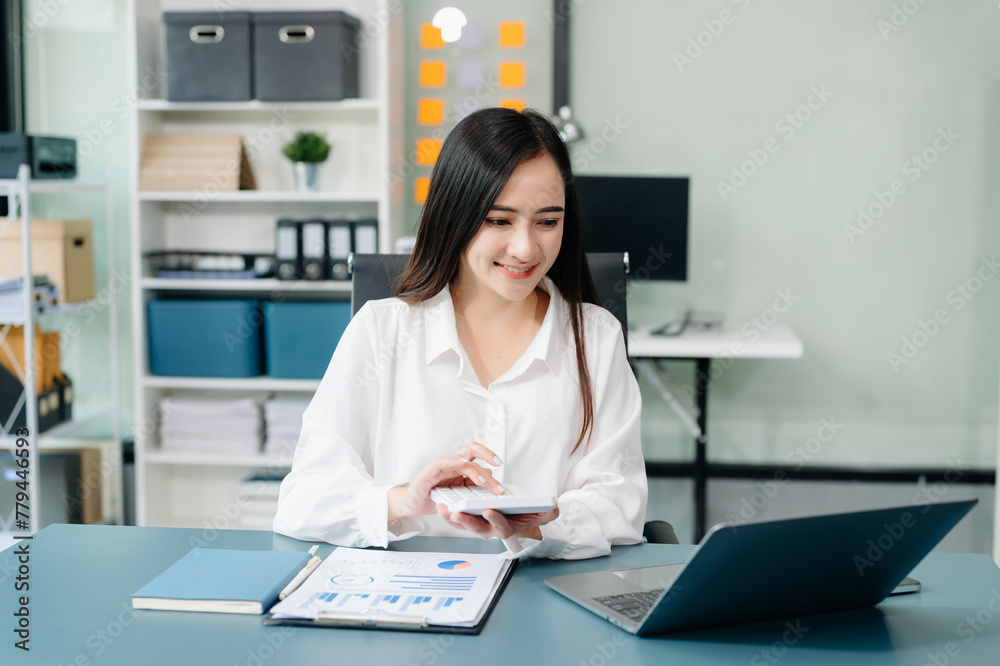 Asian businesswoman working with working notepad, tablet and laptop documents talking on the smartphone, tablet and laptop video call tax Asian businesswoman working with working notepad, tablet and laptop documents talking on the smartphone, tablet and laptop video call tax