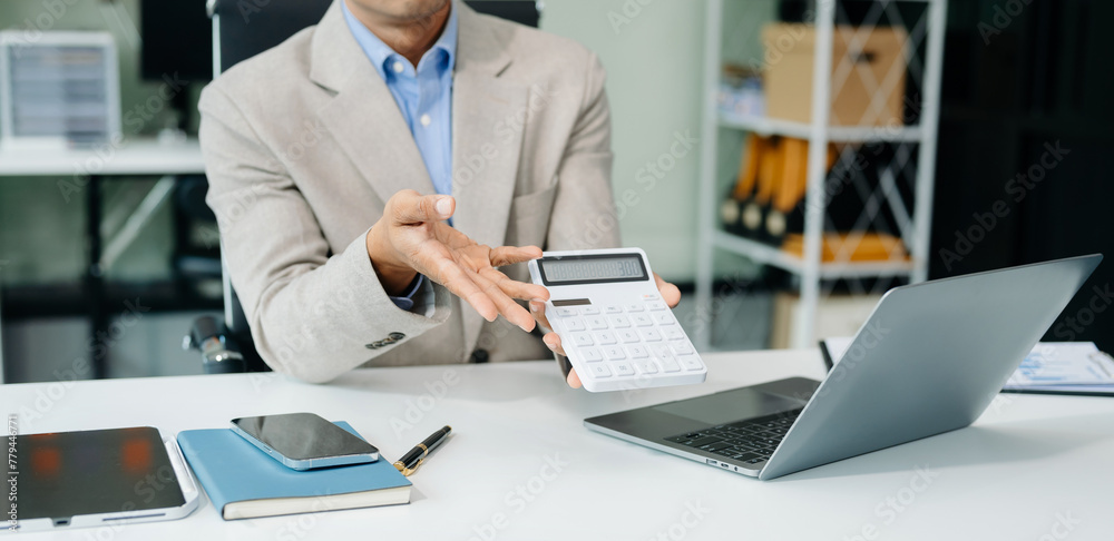 Asian businessman typing laptop and tablet Placed at the table at the office. Asian businessman typing laptop and tablet Placed at the table at the office.