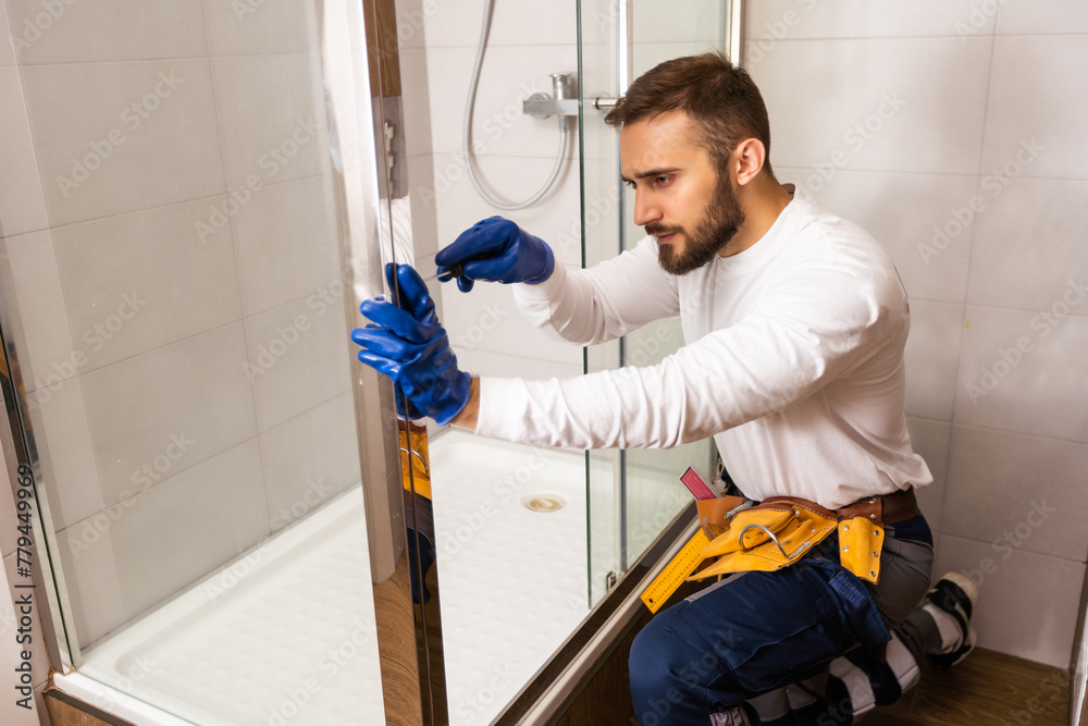 Fototapeta premium Plumber installing a shower cabin in bathroom
