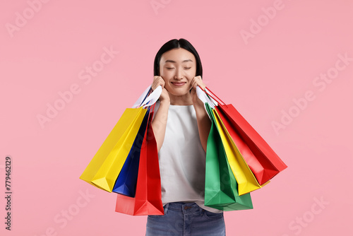 Happy woman with shopping bags on pink background © New Africa