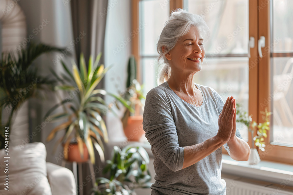 portrait of happy mature aged woman doing yoga in living room at home portrait of happy mature aged woman doing yoga in living room at home
