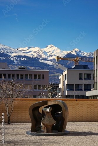 Modern sculpture among a rock garden in downtown Vaduz, Liechtenstein with the stunning alps visible in the distance