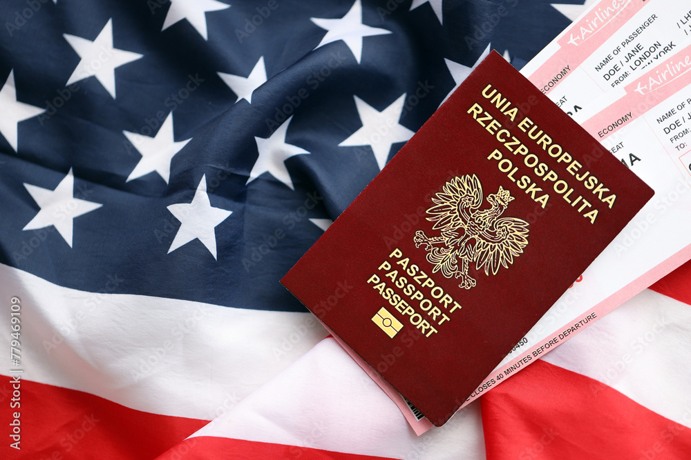 Fototapeta premium Poland passport with airline tickets on American US flag close up. Tourism and travel concept