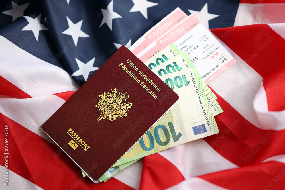 Fototapeta premium French passport and euro money with airline tickets on United States national flag background close up. Tourism and diplomacy concept