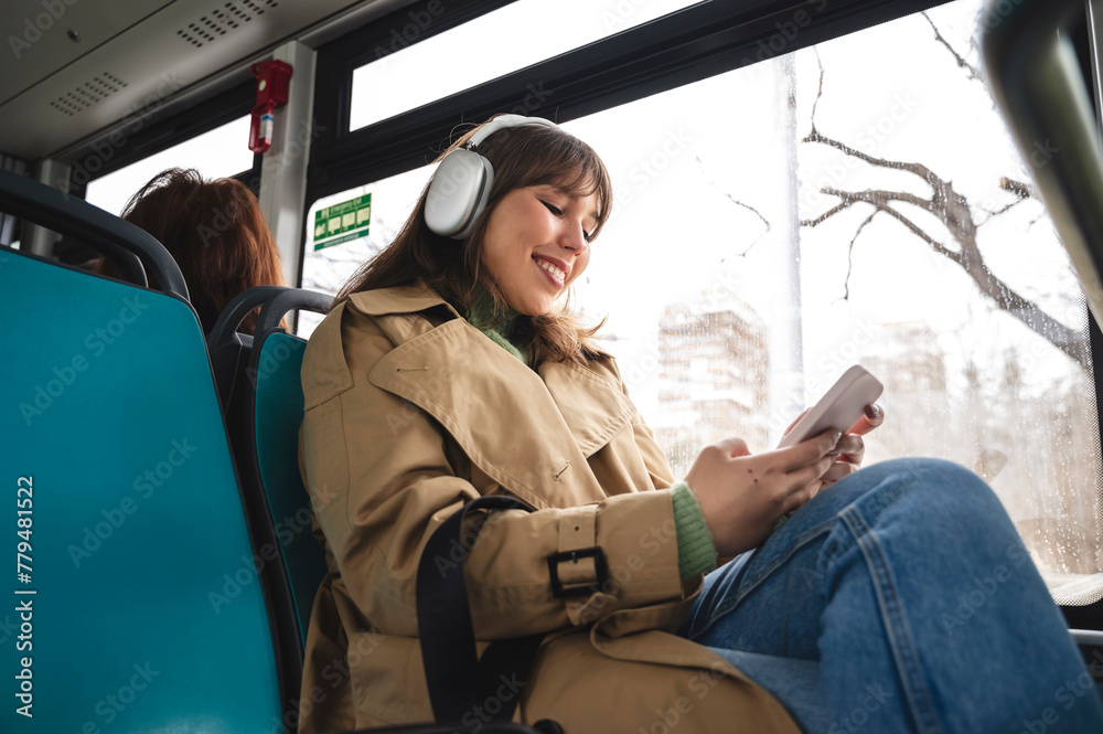Smiling woman using smart phone sitting in bus Smiling woman using smart phone sitting in bus