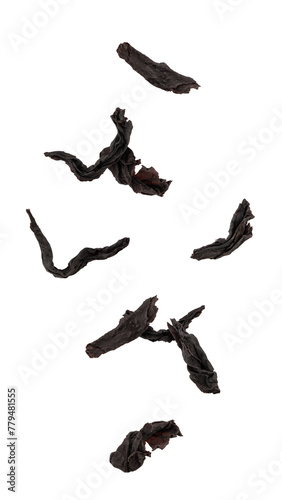 Falling black Tea leaves isolated on white background, full depth of field