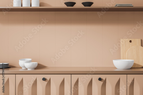 Beige home kitchen interior with kitchenware on counter and dishes