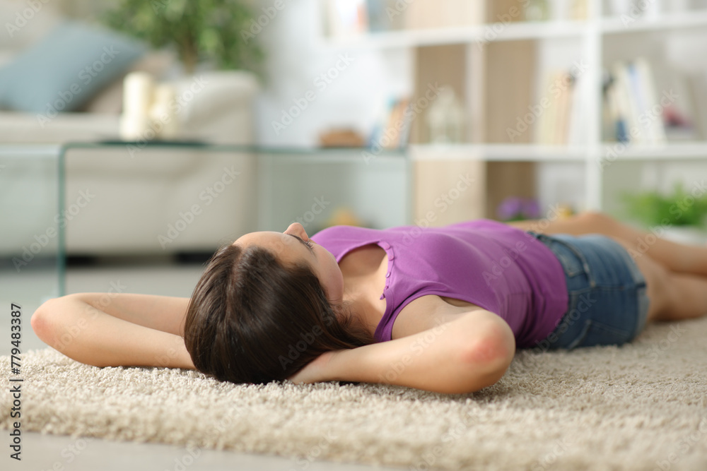 Obraz premium Woman relaxing at home lying on carpet