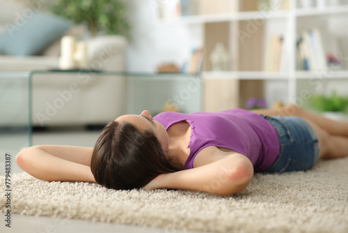 Woman relaxing at home lying on carpet