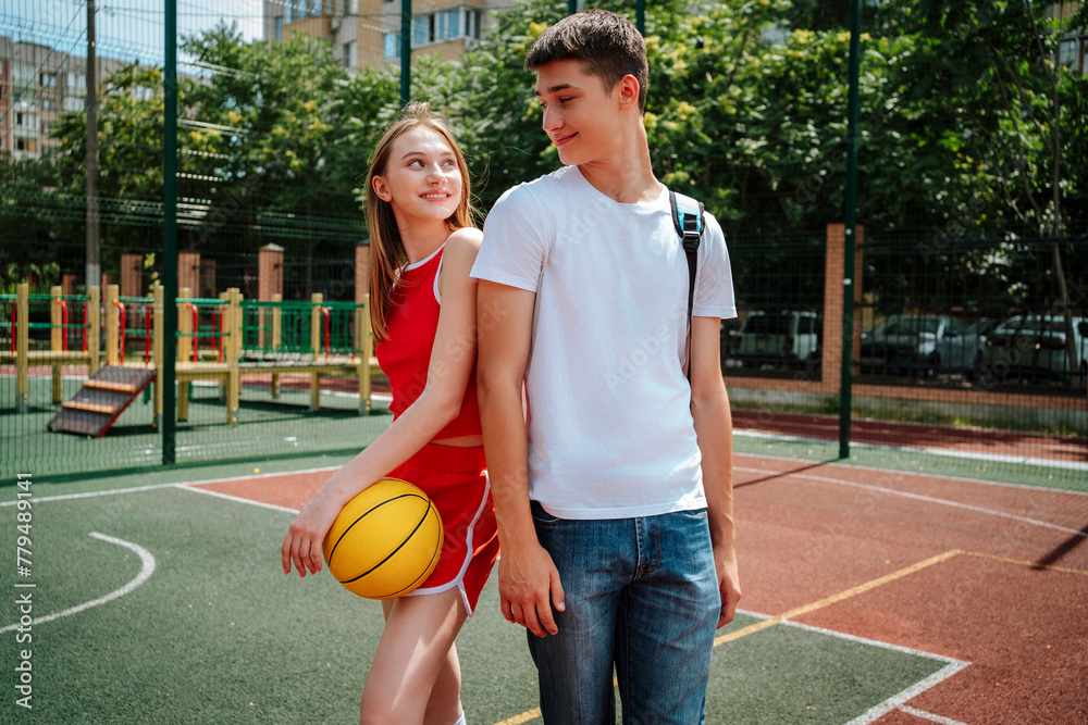 Smiling basketball player standing with friend in schoolyard Smiling basketball player standing with friend in schoolyard