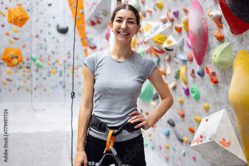 Young smiling woman in sportswear posing near training wall