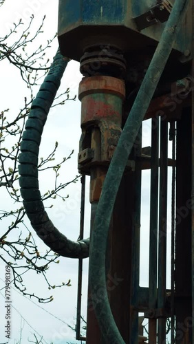 Machine element spins the forcer for drilling the ground. Machine boring the well outdoors. Vertical video. photo