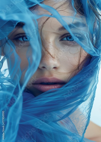Ethereal Young Woman with Striking Blue Eyes Wrapped in Tulle Fabric