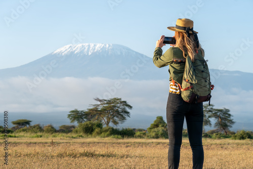 Canvas Print beautiful young girl In a hat stands against the backdrop of the Kilimanjaro volcano and looks away