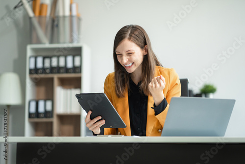 Overjoyed charming excited black woman business woman worker using smartphone and laptop working in office, feeling happy.