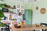 Caucasian cheerful young woman is engaged while spending time cooking in the kitchen