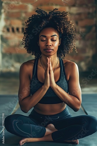 A woman is sitting on a mat and praying
