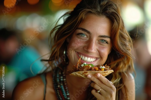 A close-up of a woman happily eating a taco