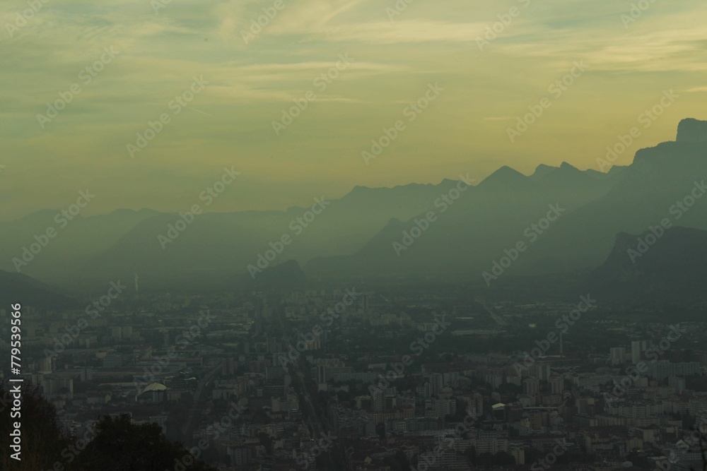 Aerial view of a city in mountains on a foggy day at sunset