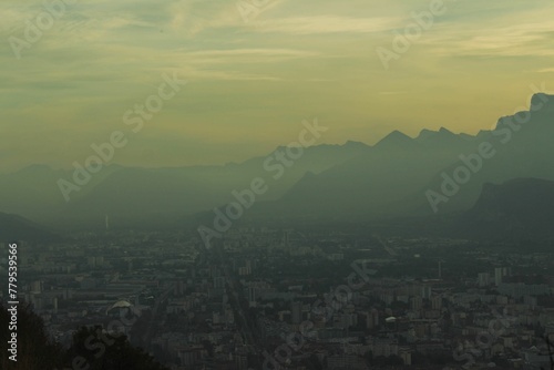 Aerial view of a city in mountains on a foggy day at sunset