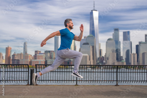 Run. Healthy Man running in New York City. Fitness sport, man runner is jogging near Manhattan. Man running on American street. Man running in New York in sport clothes. Sport wear for mature runners. photo