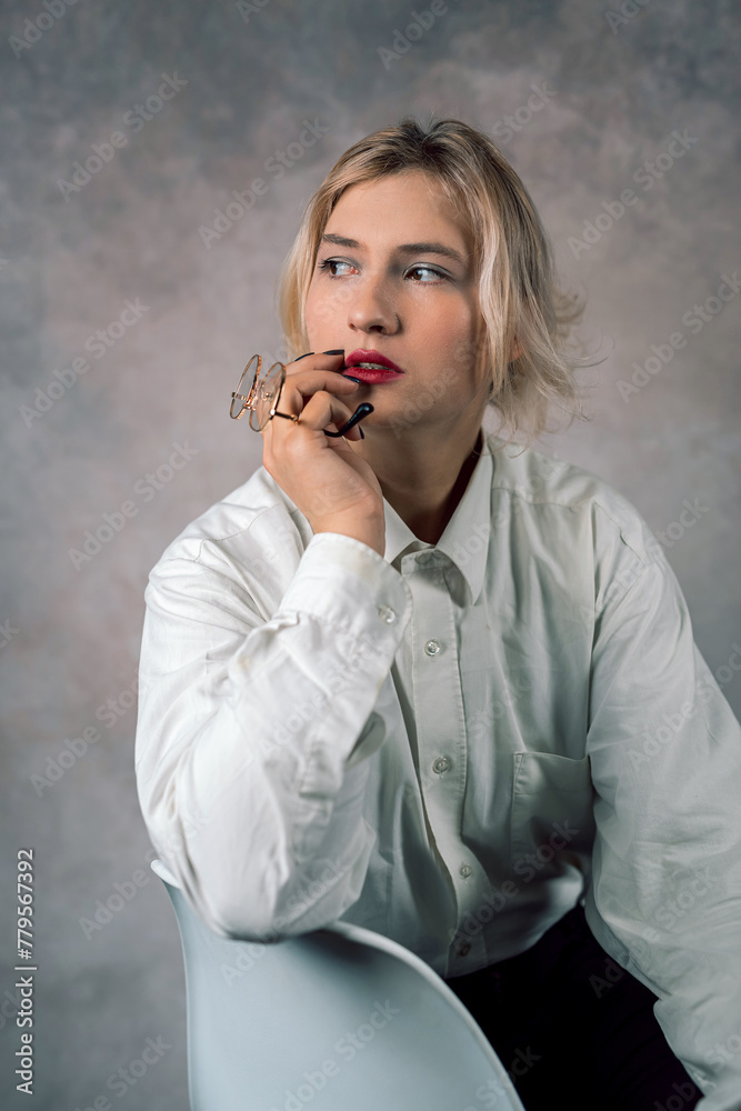 photo of attractive gorgeous business woman sitting on chair wearing suit isolated on plain background photo of attractive gorgeous business woman sitting on chair wearing suit isolated on plain background