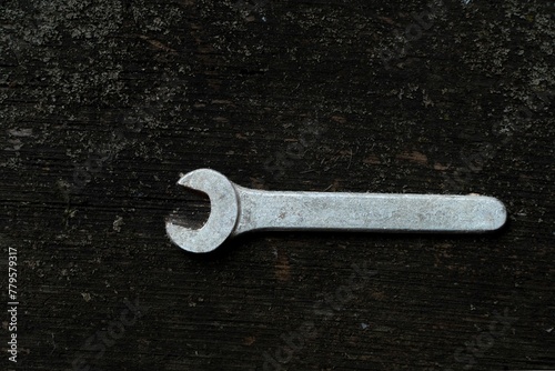 Top view of a metal wrench on a wooden surface © Wirestock