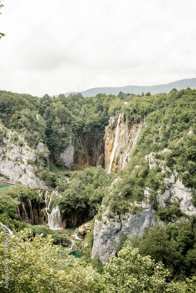 Vertical shot of rocky landscapes covered in greenery in Plitvice Lakes National Park, Croatia