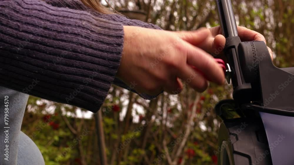 Hand fixing lawnmower in garden Hand fixing lawnmower in garden