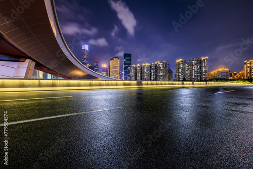 Asphalt highway road and bridge with city buildings at night