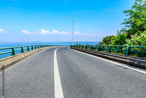 Asphalt highway road and green tree landscape by the sea