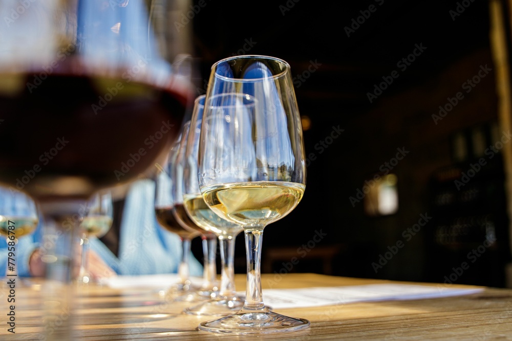 Low-angle shallow focus of glass cups filled with drinks in a row on a wooden surface Low-angle shallow focus of glass cups filled with drinks in a row on a wooden surface